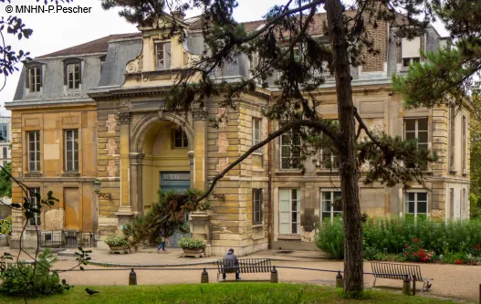 HOTEL DE MAGNY - Jardin des Plantes Bâtiment historique en pierre avec porte d'entrée et arbres autour.