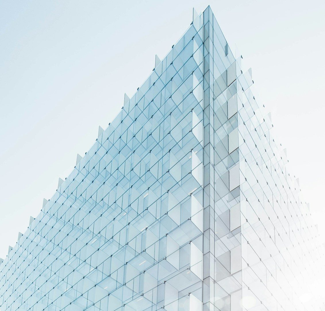 Façade d'un bâtiment en verre moderne, angulaire et lumineux.