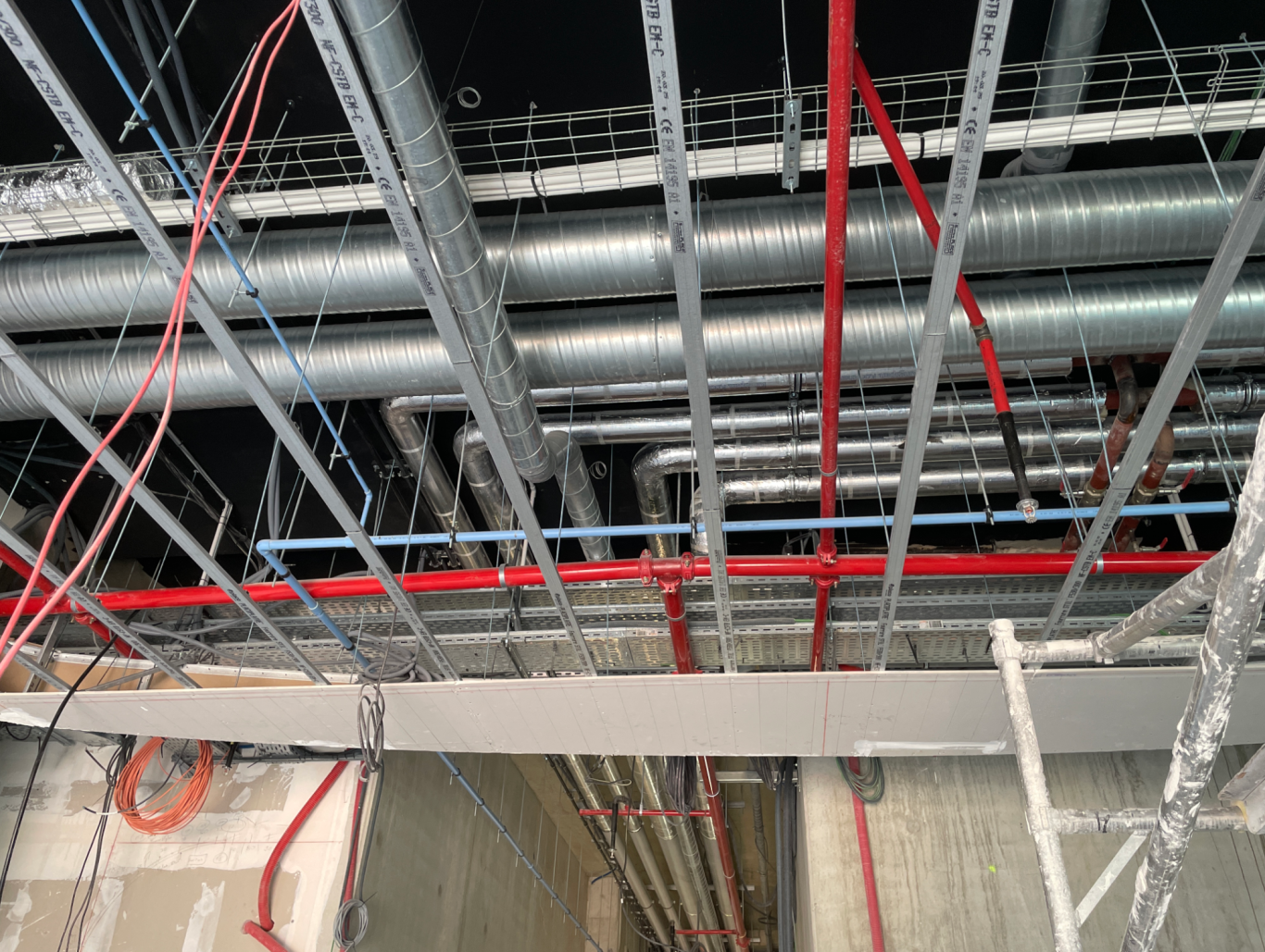 Structure de plafond avec conduits métalliques et éclairage.